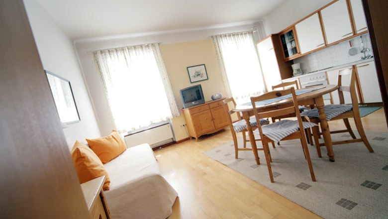 House Weissenbacher, © weinfranz.at Bright living room with sofa, dining table and kitchenette.