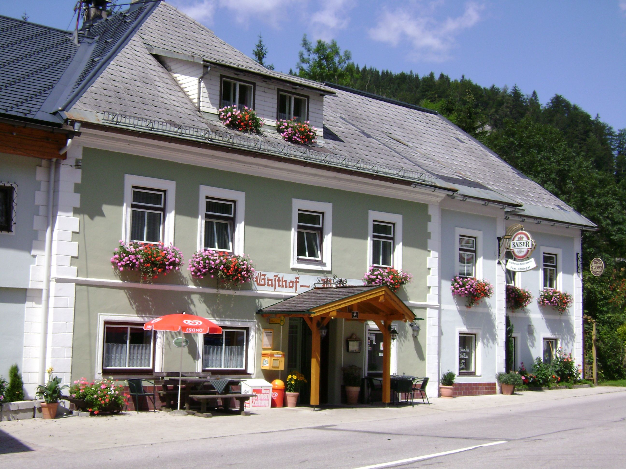 Traditional inn with flower boxes and emperor's beer sign.