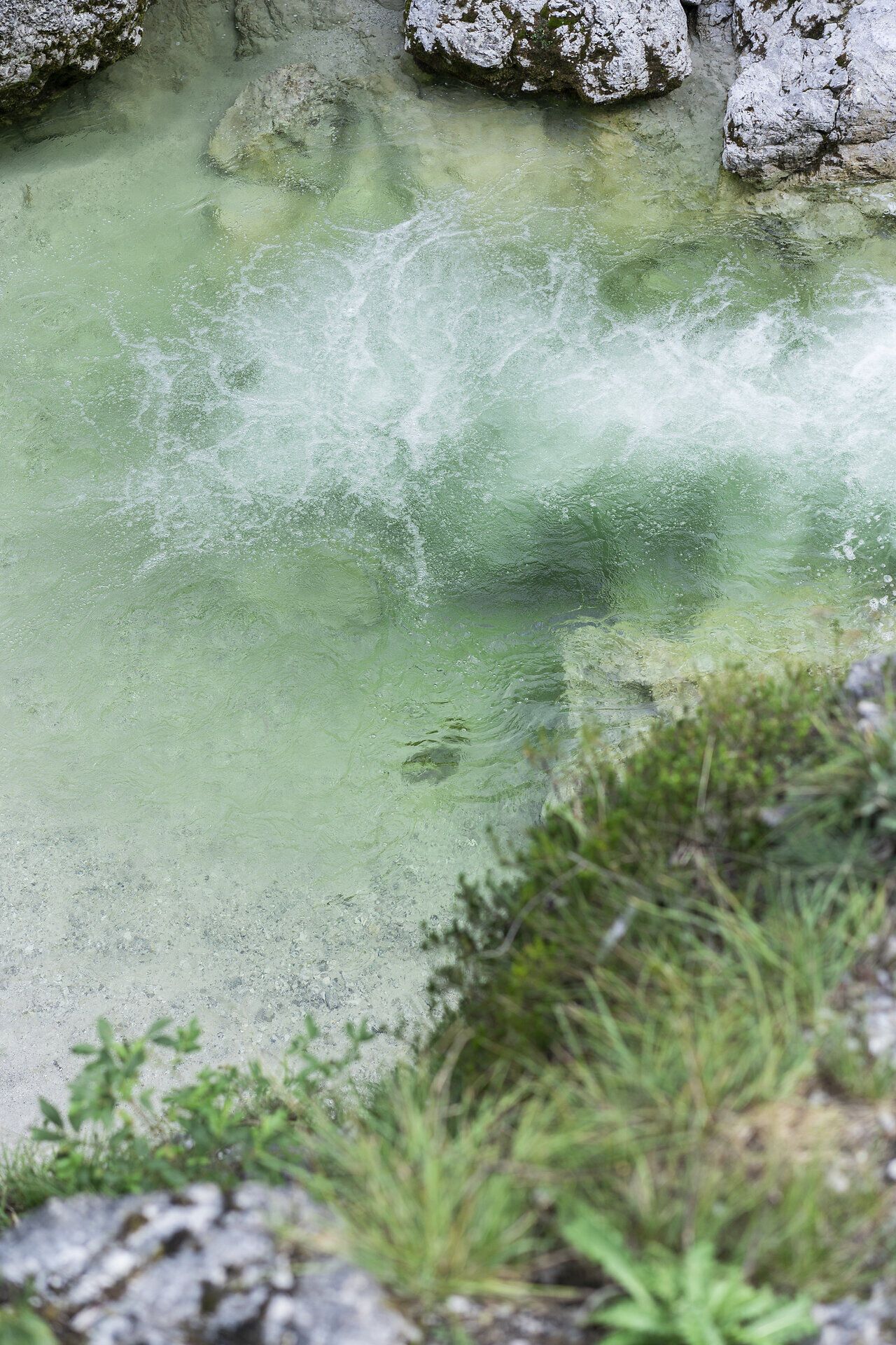 Kristallklares Wasser sprudelt sanft über die glatten Steine und schafft eine harmonische Melodie der Natur. Umgeben von üppigem Grün und majestätischen Felsen, lädt dieser Ort zum Verweilen und Entspannen ein. Hier, im Herzen des Naturparks, entfaltet sich die Schönheit der alpinen Landschaft in voller Pracht.