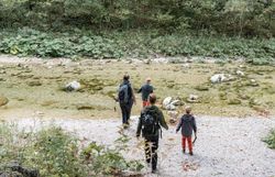 Die sanften Wellen des klaren Wassers spiegeln die umgebenden Bäume wider, während die Wanderer in entspannter Atmosphäre den Weg entlang der Uferlinie erkunden. Die frische Herbstluft und das Rascheln der Blätter schaffen eine harmonische Kulisse für unvergessliche Erlebnisse in der Natur.
