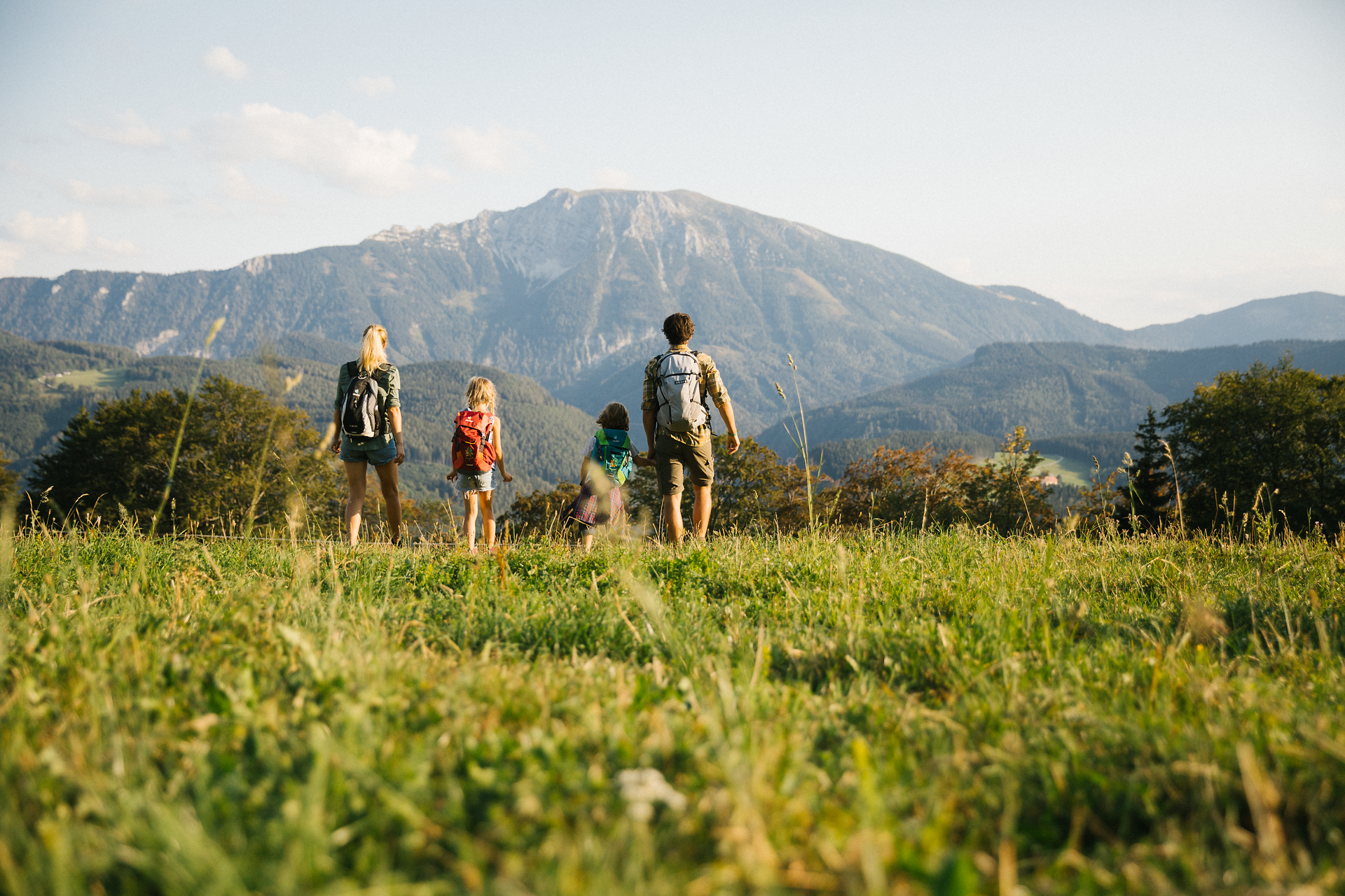 Eine Familie genießt den atemberaubenden Ausblick auf die majestätischen Berge, während sie gemeinsam die Wanderwege erkundet. Die sanften Hügel und die frische Bergluft laden zu unvergesslichen Erlebnissen in der Natur ein.