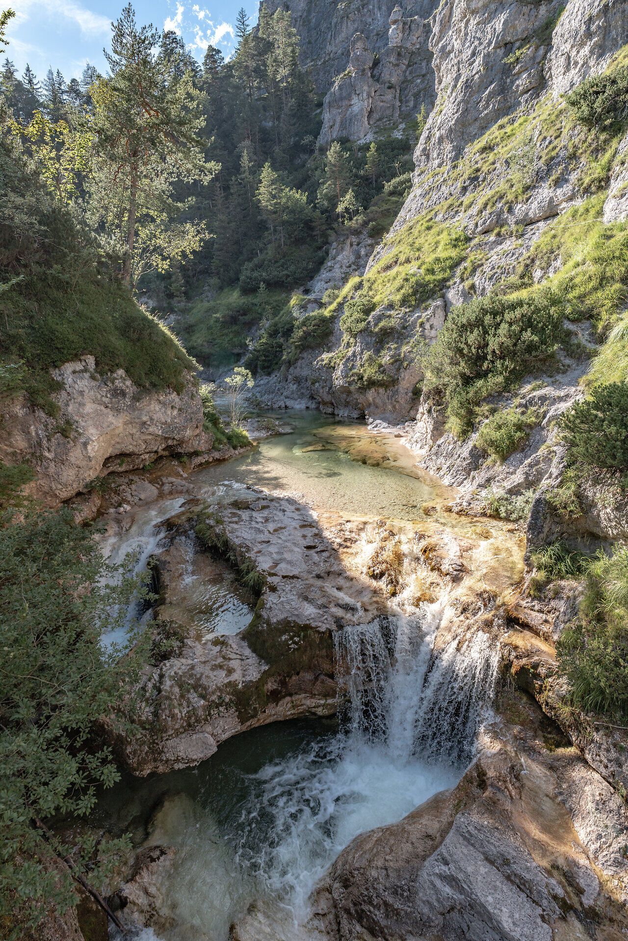 Kristallklares Wasser plätschert sanft über die Felsen und schafft eine harmonische Melodie der Natur. Umgeben von üppigem Grün und majestätischen Felsen lädt diese idyllische Landschaft zum Verweilen und Entdecken ein. Hier, wo die Ruhe der Berge auf die Frische des Wassers trifft, wird jeder Schritt zu einem unvergesslichen Erlebnis.