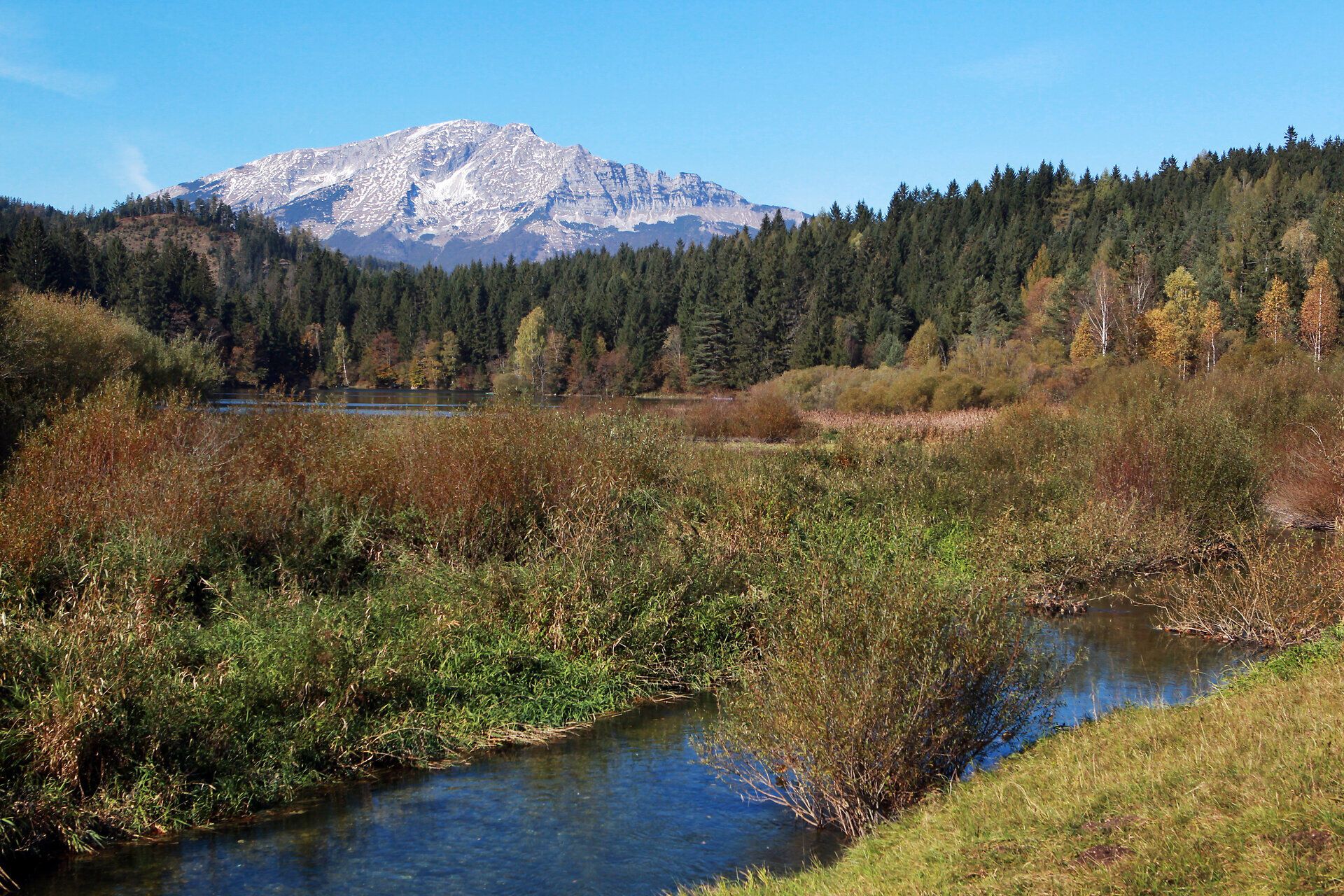 Die majestätischen Gipfel des Ötschers erheben sich stolz über die sanften Hügel und den glitzernden Erlaufstausee. Umgeben von üppigem Grün und bunten Herbstfarben, lädt diese idyllische Landschaft zum Verweilen und Entdecken ein. Hier, wo die Natur in voller Pracht erstrahlt, spürt man die Ruhe und den Zauber der Berge.