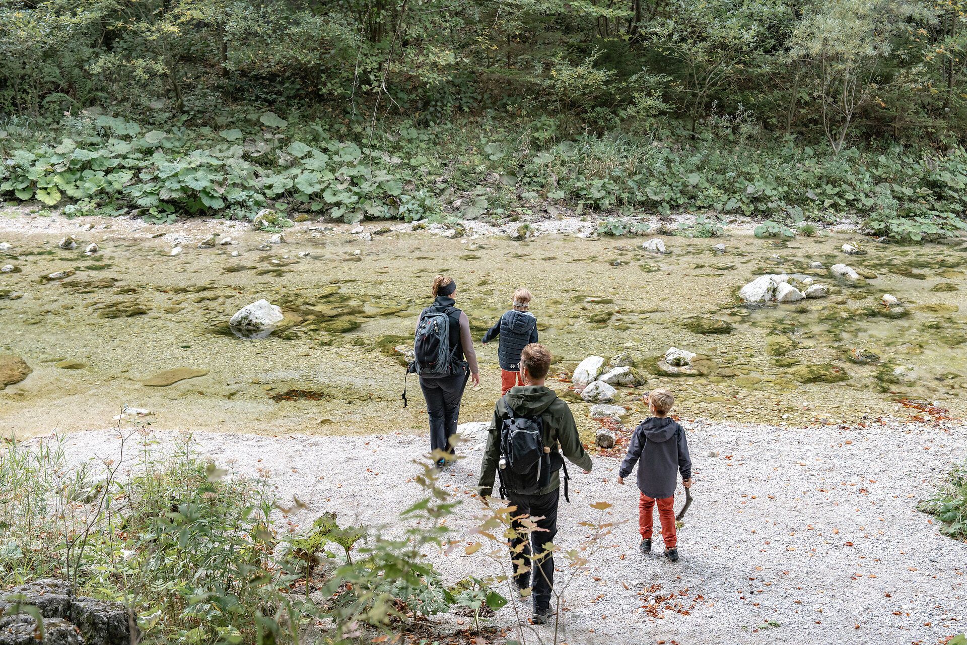 Die sanften Wellen des klaren Wassers spiegeln die umgebenden Bäume wider, während die Wanderer in entspannter Atmosphäre den Weg entlang der Uferlinie erkunden. Die frische Herbstluft und das Rascheln der Blätter schaffen eine harmonische Kulisse für unvergessliche Erlebnisse in der Natur.