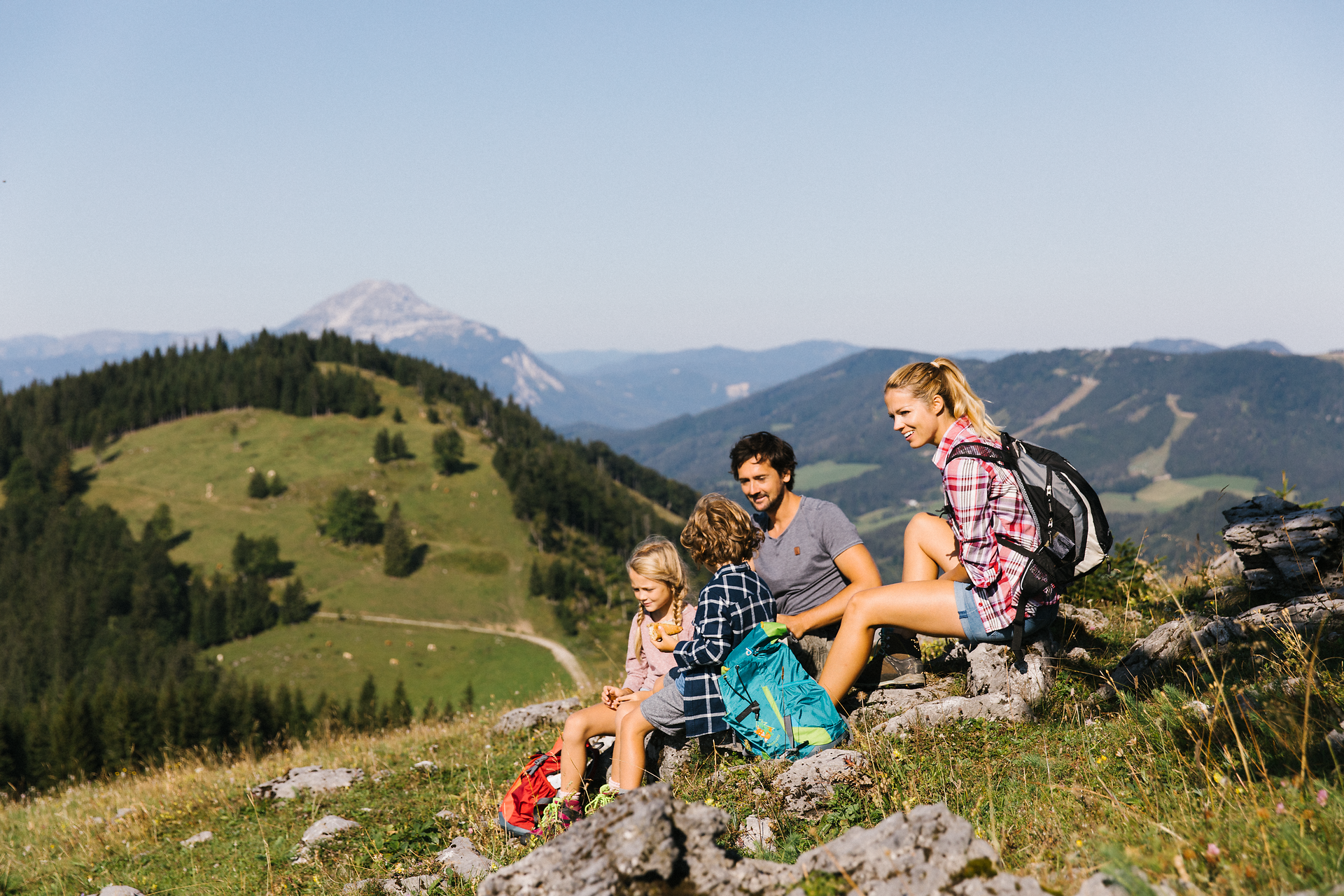 Eine fröhliche Familie genießt die atemberaubende Aussicht auf die sanften Hügel und die majestätischen Berge. Umgeben von üppigem Grün und blühenden Wildblumen, erleben sie unvergessliche Momente in der Natur. Hier wird das Wandern zum gemeinsamen Abenteuer, das die Herzen verbindet.