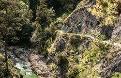 Ein malerischer Pfad schlängelt sich entlang der steilen Felsen, umgeben von üppigem Grün und dem sanften Plätschern des klaren Wassers. Die frische Bergluft und die atemberaubenden Ausblicke laden dazu ein, die Natur in vollen Zügen zu genießen und neue Energie zu tanken.