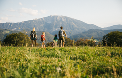 Eine Familie genießt den atemberaubenden Ausblick auf die majestätischen Berge, während sie gemeinsam die Wanderwege erkundet. Die sanften Hügel und die frische Bergluft laden zu unvergesslichen Erlebnissen in der Natur ein.
