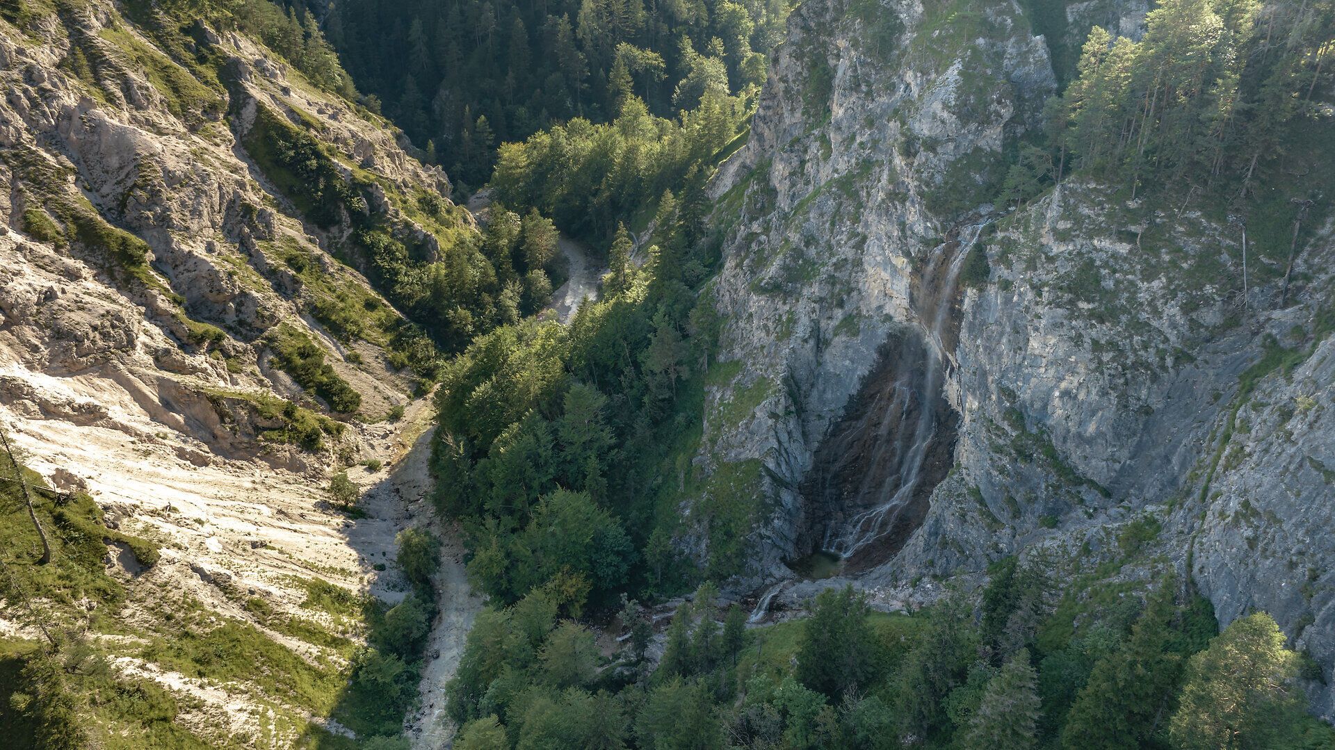 Die majestätischen Felsen erheben sich steil über den grünen Wäldern, während ein sanfter Wasserfall in die Tiefe plätschert. Hier, im Herzen des Naturparks, entfaltet sich die unberührte Schönheit der Natur und lädt Wanderer zu unvergesslichen Erlebnissen ein.