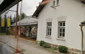 Bahnhof Mitterbach mit weißem Gebäude und Blumen.