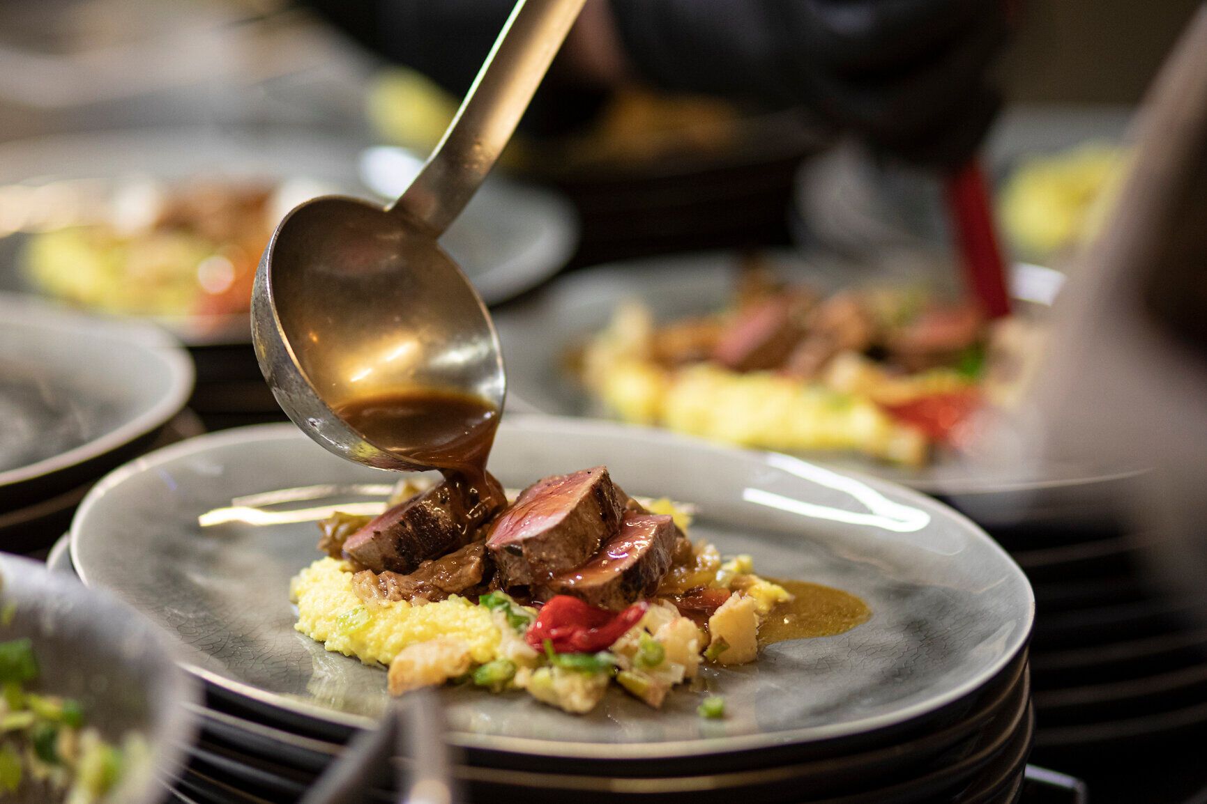 Ein köstliches Gericht wird mit einer aromatischen Sauce verfeinert, während die Köche in der Küche mit Leidenschaft und Präzision arbeiten. Die harmonische Kombination aus zartem Fleisch und cremigem Püree verspricht ein unvergessliches Geschmackserlebnis inmitten der idyllischen Natur des Mostviertels.