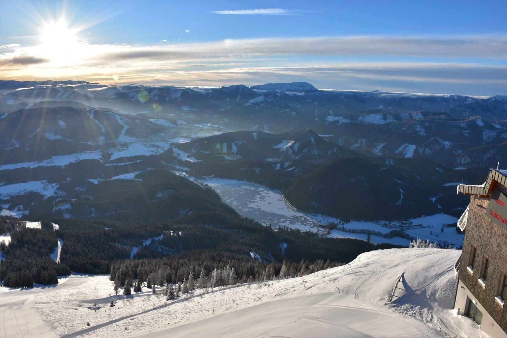 Winterlandschaft mit schneebedeckten Bergen und dem gefrorenen Erlaufsee im Sonnenuntergang.