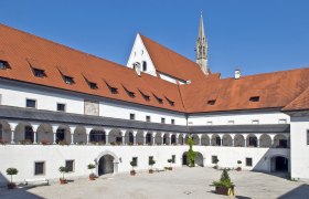 Innenhof der Kartause Gaming mit Arkaden und rotem Ziegeldach.