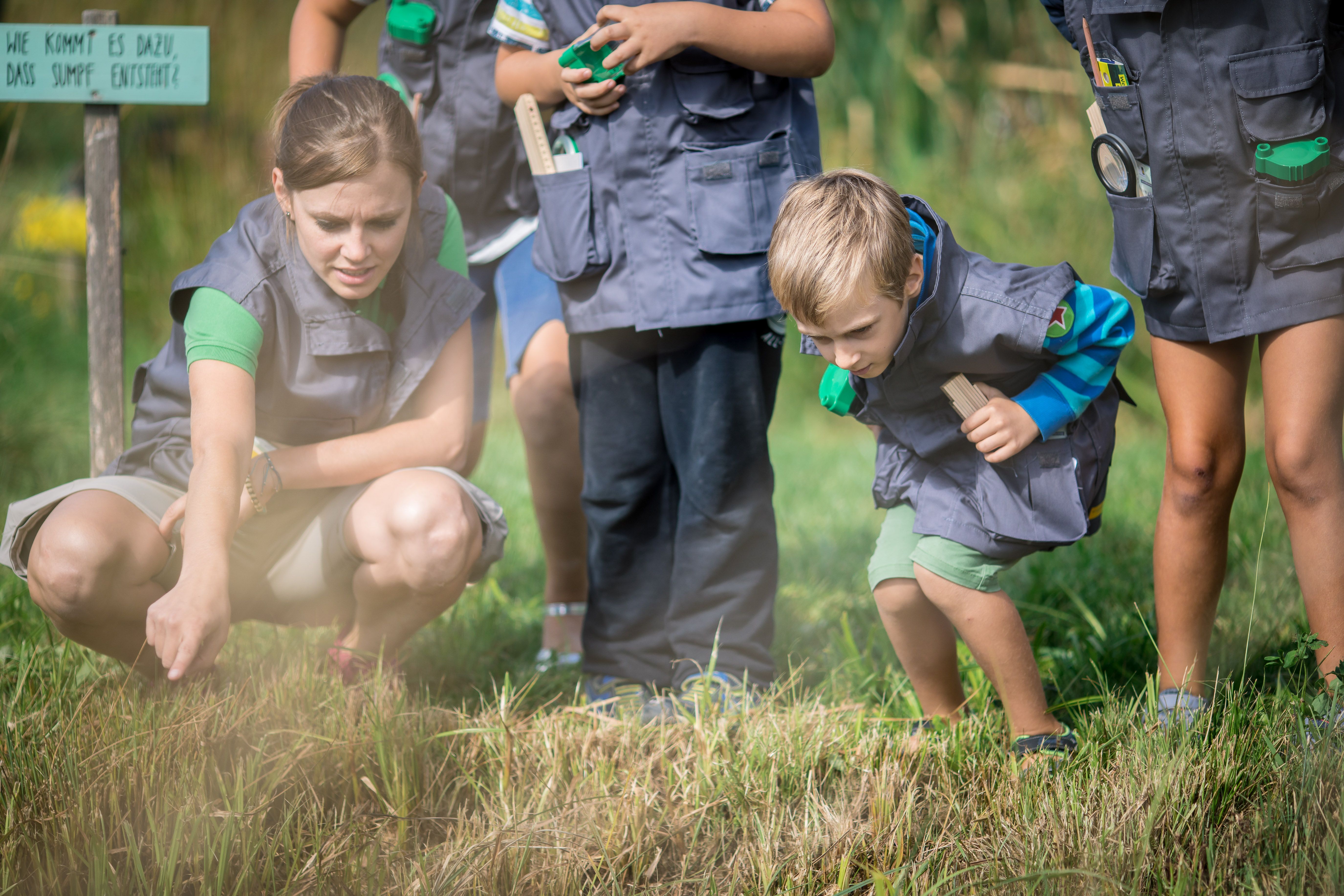 Naturvermittlerin und Kind blicken in ein Biotop