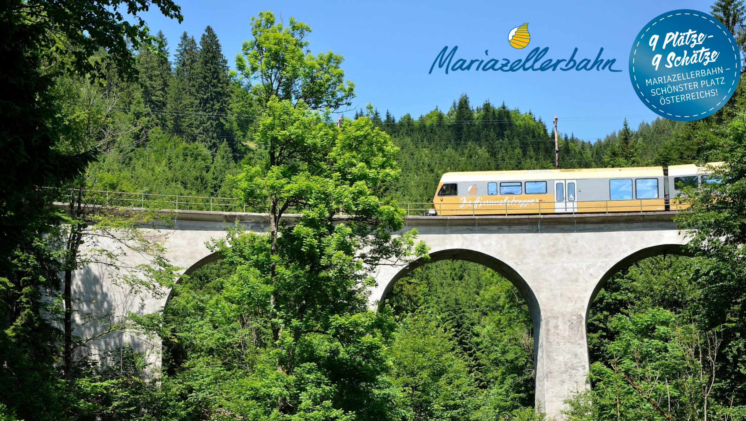 Ein Zug der Mariazellerbahn fährt über einen Viadukt im Naturpark Ötscher-Tormäuer. 