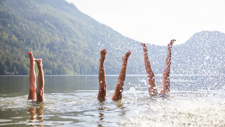 Die warmen Sonnenstrahlen tanzen auf der Wasseroberfl&auml;che, w&auml;hrend fr&ouml;hliche Menschen mit ihren Beinen im klaren Wasser planschen. Umgeben von majest&auml;tischen Bergen und &uuml;ppigem Gr&uuml;n, vermittelt dieser Ort ein Gef&uuml;hl von Freiheit und Lebensfreude. Hier wird der Sommer in seiner sch&ouml;nsten Form erlebt.